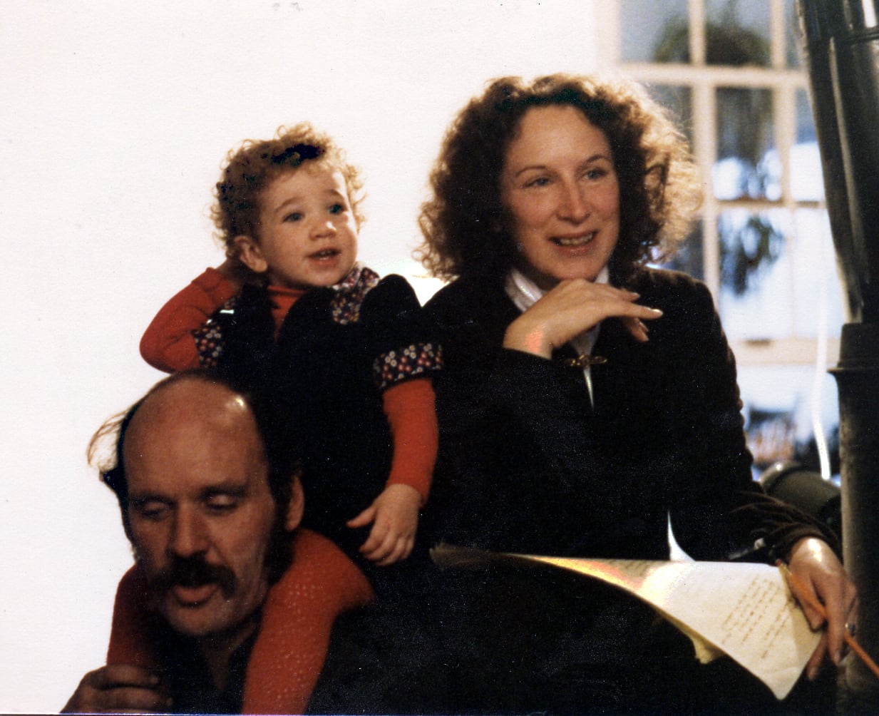 A man, woman and young child in a candid photo