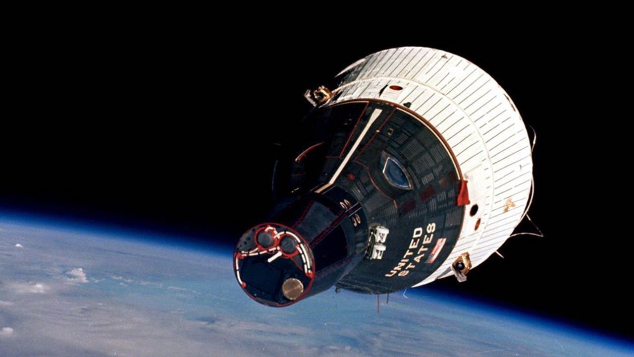 a '60s-era space capsule in orbit over the Earth